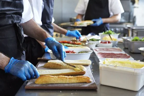Kuchař připravuje sendvič v kuchyni restaurace