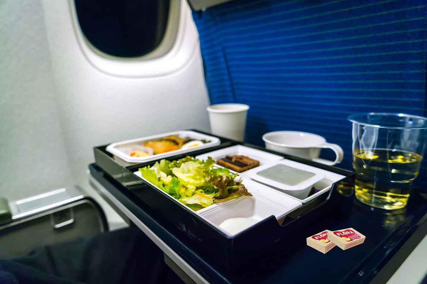 Szene im Flugzeug mit Frühstück auf dem die Flora Professional Butteralternative Portionspackungen zu sehen sind