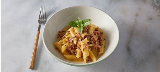 recipe image Πέννες a la cream με προσούτο και καραμελωμένα κρεμμύδια