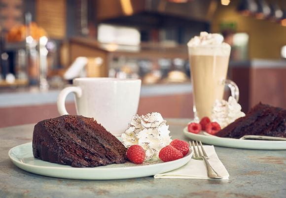 Csokoládétorta és latte kávé a kávézó asztalán