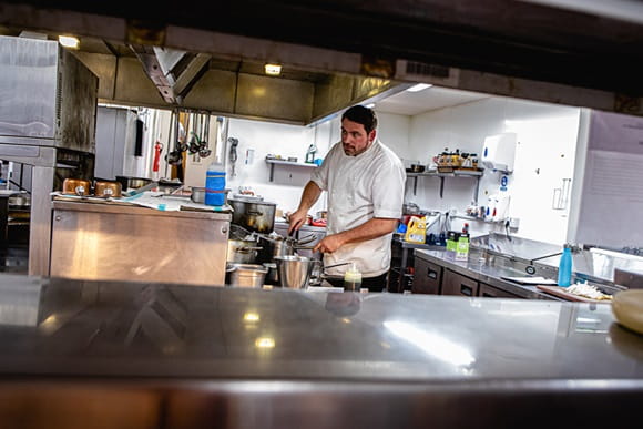 Virėjas gamina maistą restorano virtuvėje