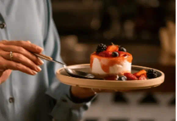 A person holding a plate of fruit cake