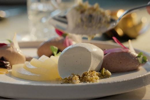 recipe image Gepocheerde Peer-Acai Mousse met Karamel- en Kardemomijs.