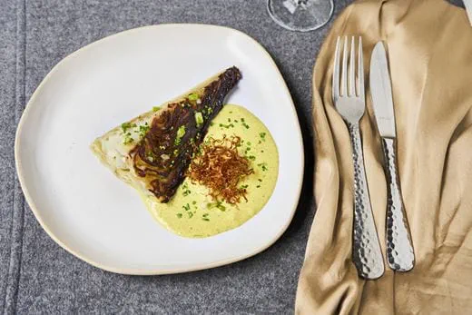 recipe image Gekarameliseerde spitskool met romige currysaus en krokante zuurkool