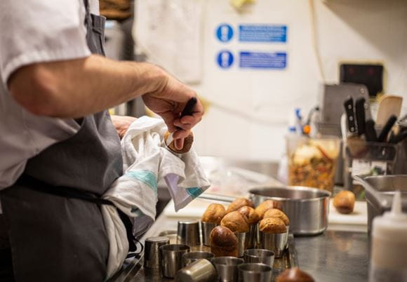 Kucharz wyjmujący babeczki z formy