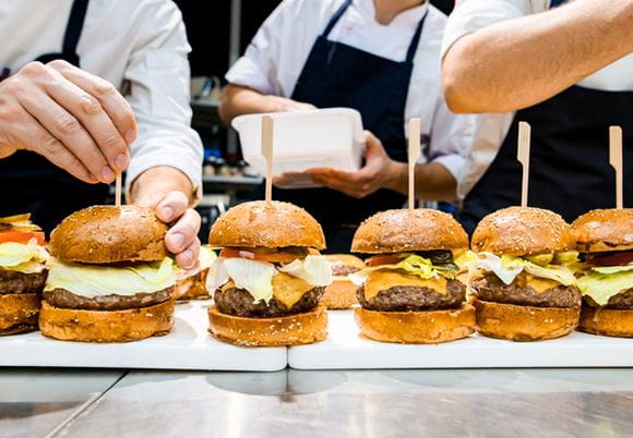 Kucharze przygotowujący hamburgery