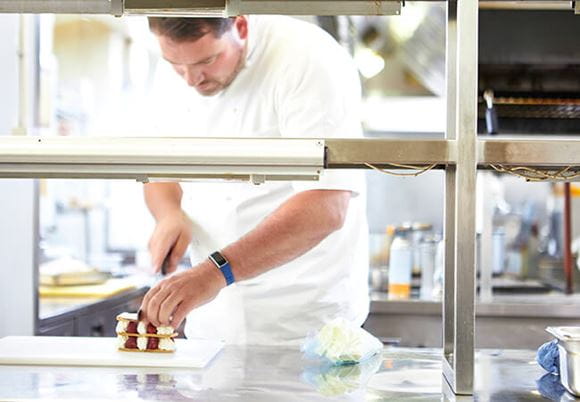 Kucharz krojący ciasto w restauracyjnej kuchni