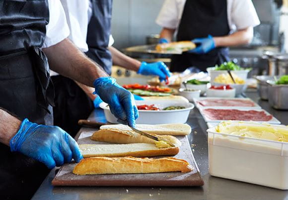 Kucharz przygotowujący kanapkę w restauracyjnej kuchni