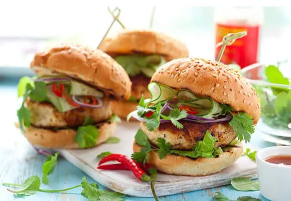 Trzy hamburgery podane na błękitnym talerzu