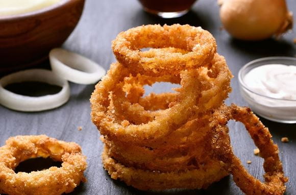 Petisco de aros de cebola fritos acompanhados com maionese